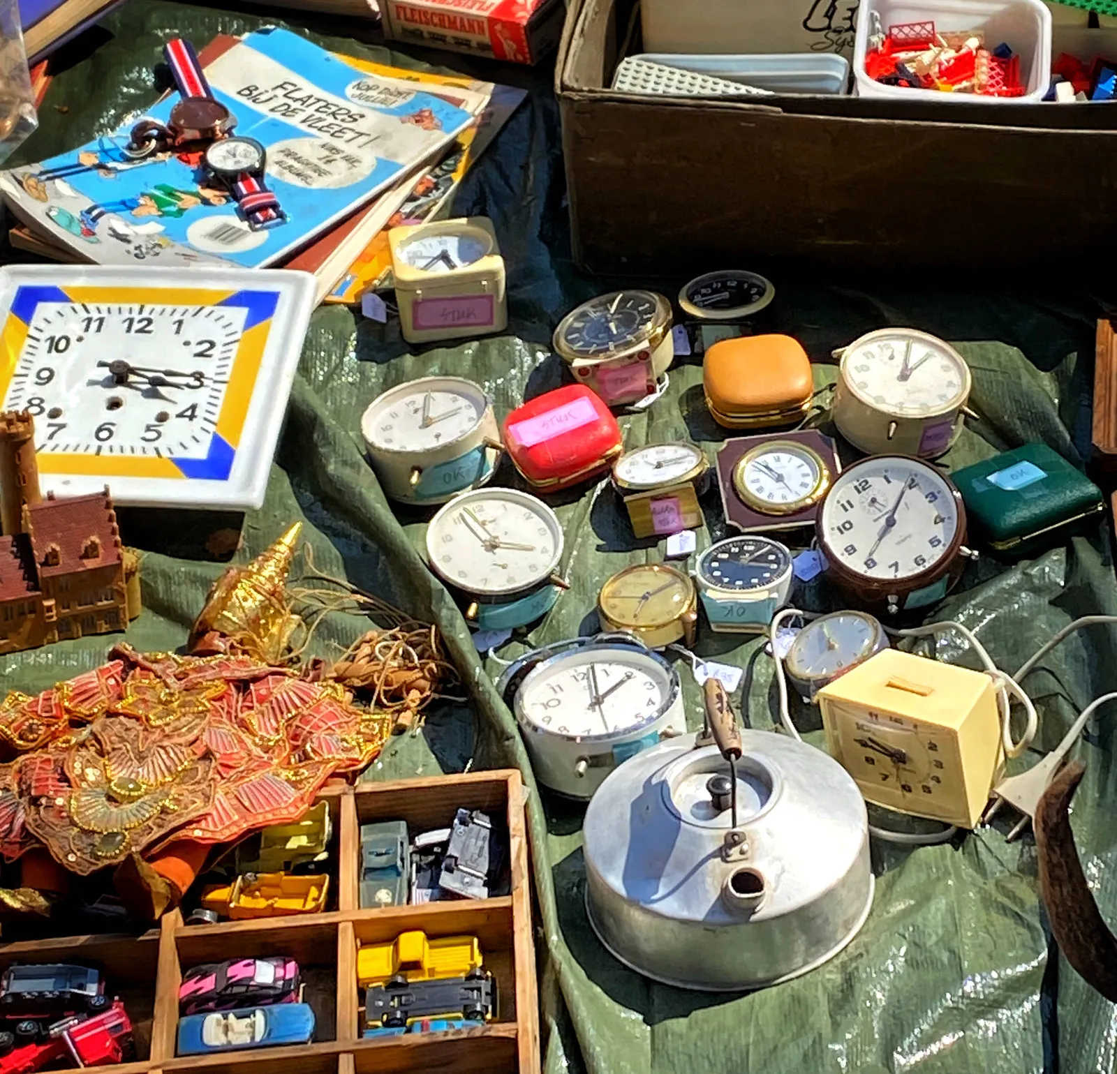 There are quite a few clocks lying on a plastic sheet on a flea market. On some of them the time can be seen. Most of them point at the wrong time, but on one of them it is 5 minutes past 3, which is correct.