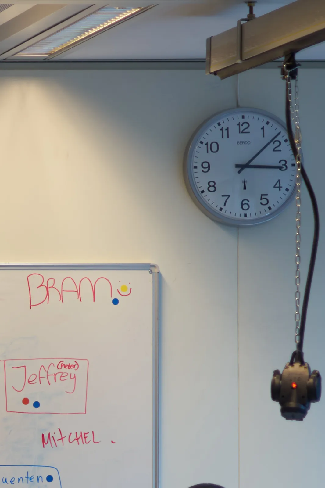 A clock in a classroom points at 8 past 3.