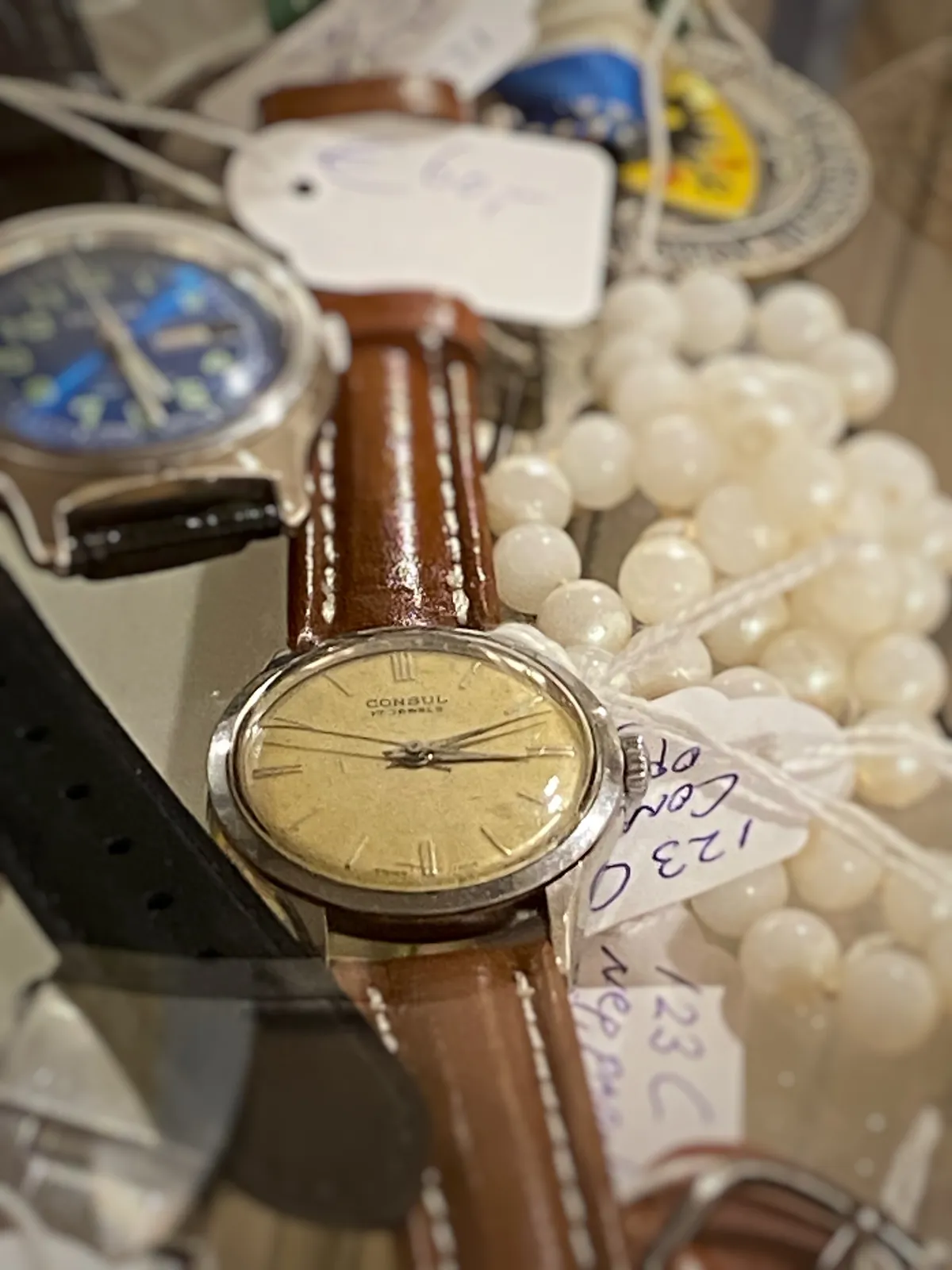 A few wrist watches for sale here. Just one of them is clearly in focus. It points at 11 past 3.