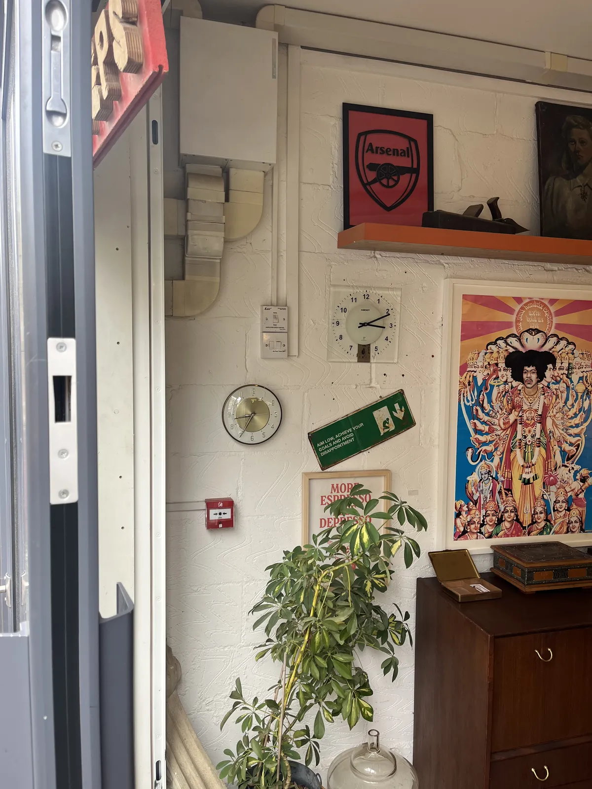 Colourful posters on the wall, an old, wooden plane (the tool, not the one for flying) and two clocks. One of them points at 11 minutes past three, the other at 34 minutes past eight.