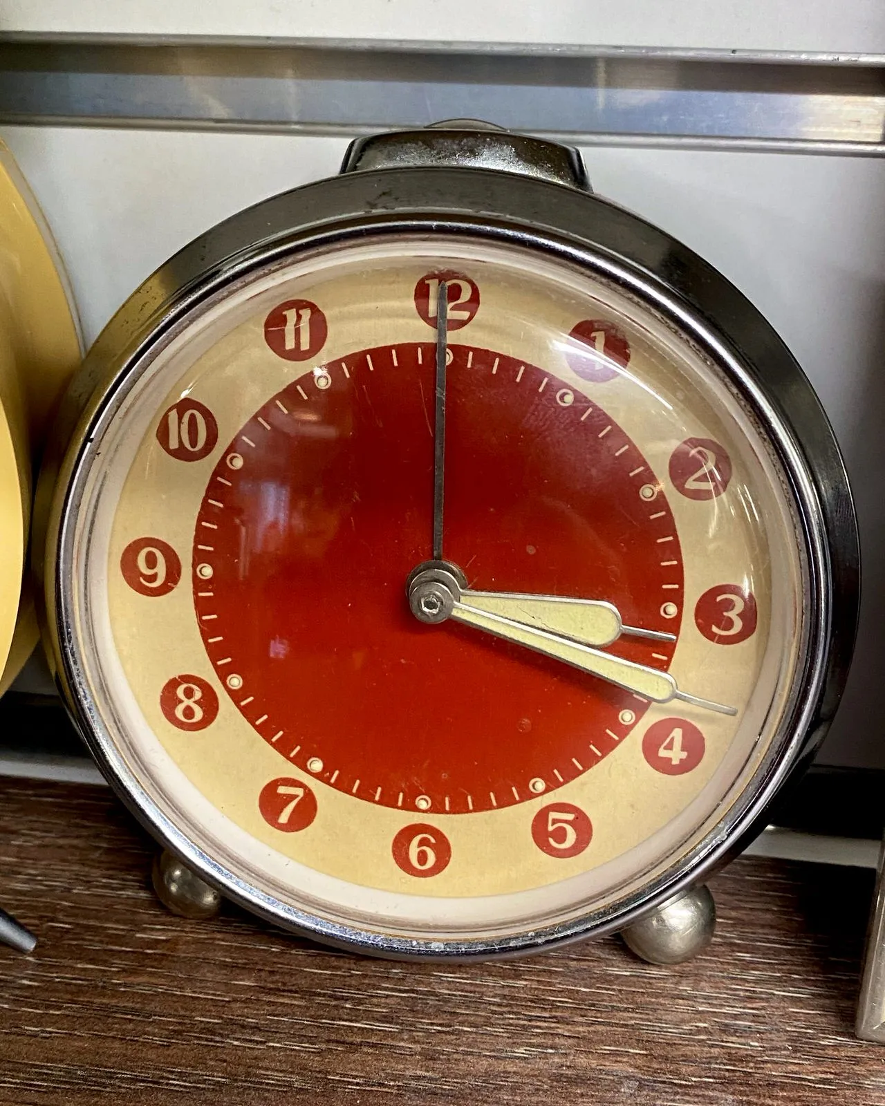 This elegant red and yellow clock points at 18 past 3.