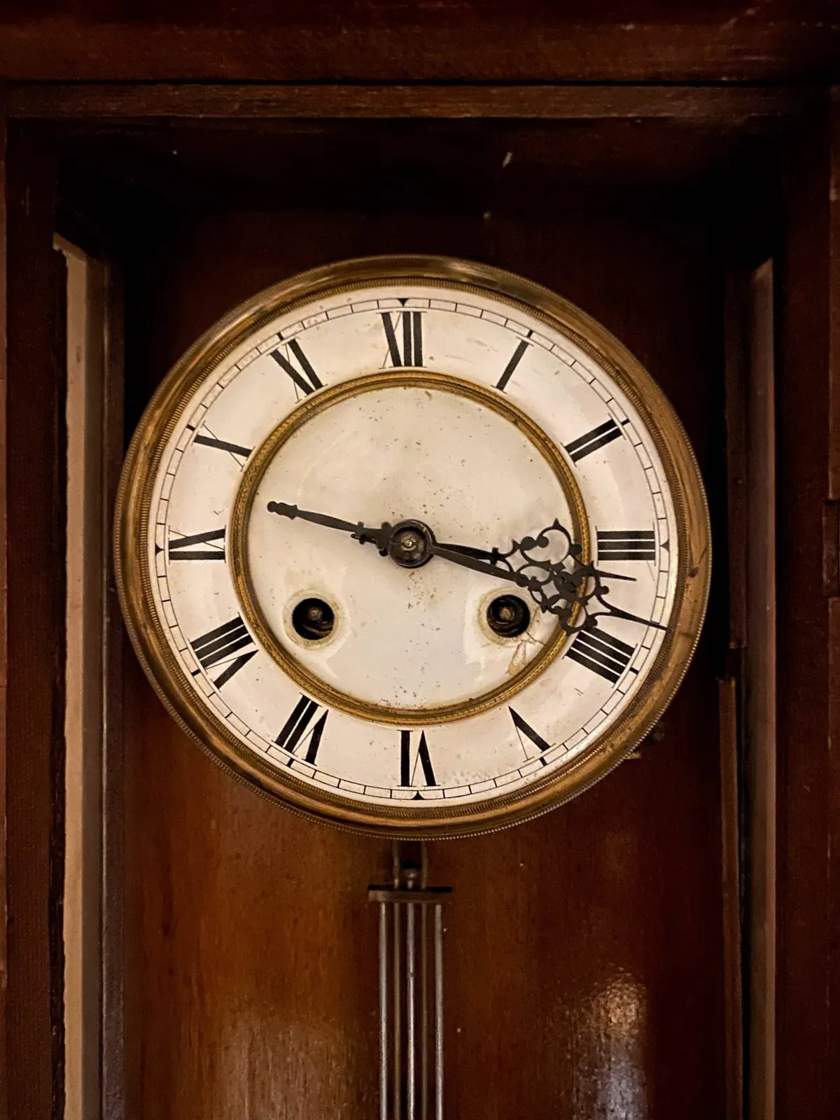 An old, wooden clock points at 18 minutes past 3.