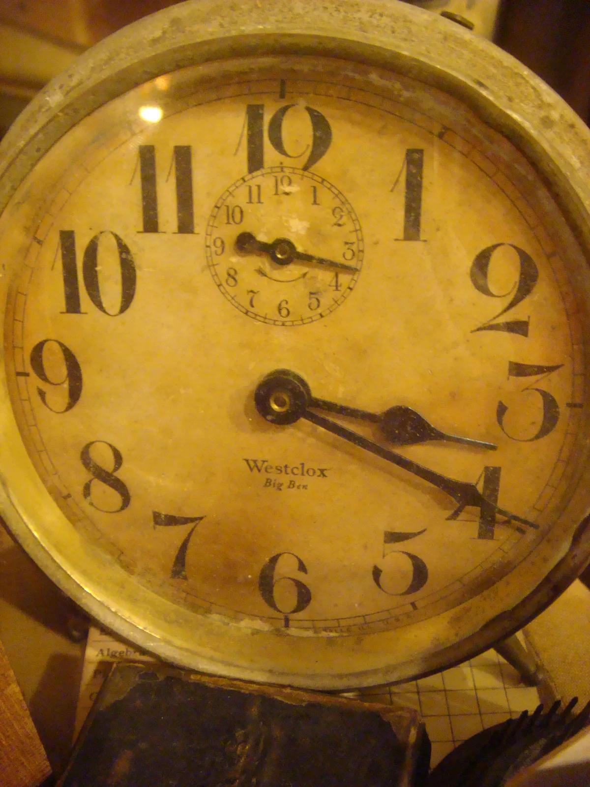 A closeup of a white clock. It says Westclox Big Ben on its face. It points at 19 minutes past 3.