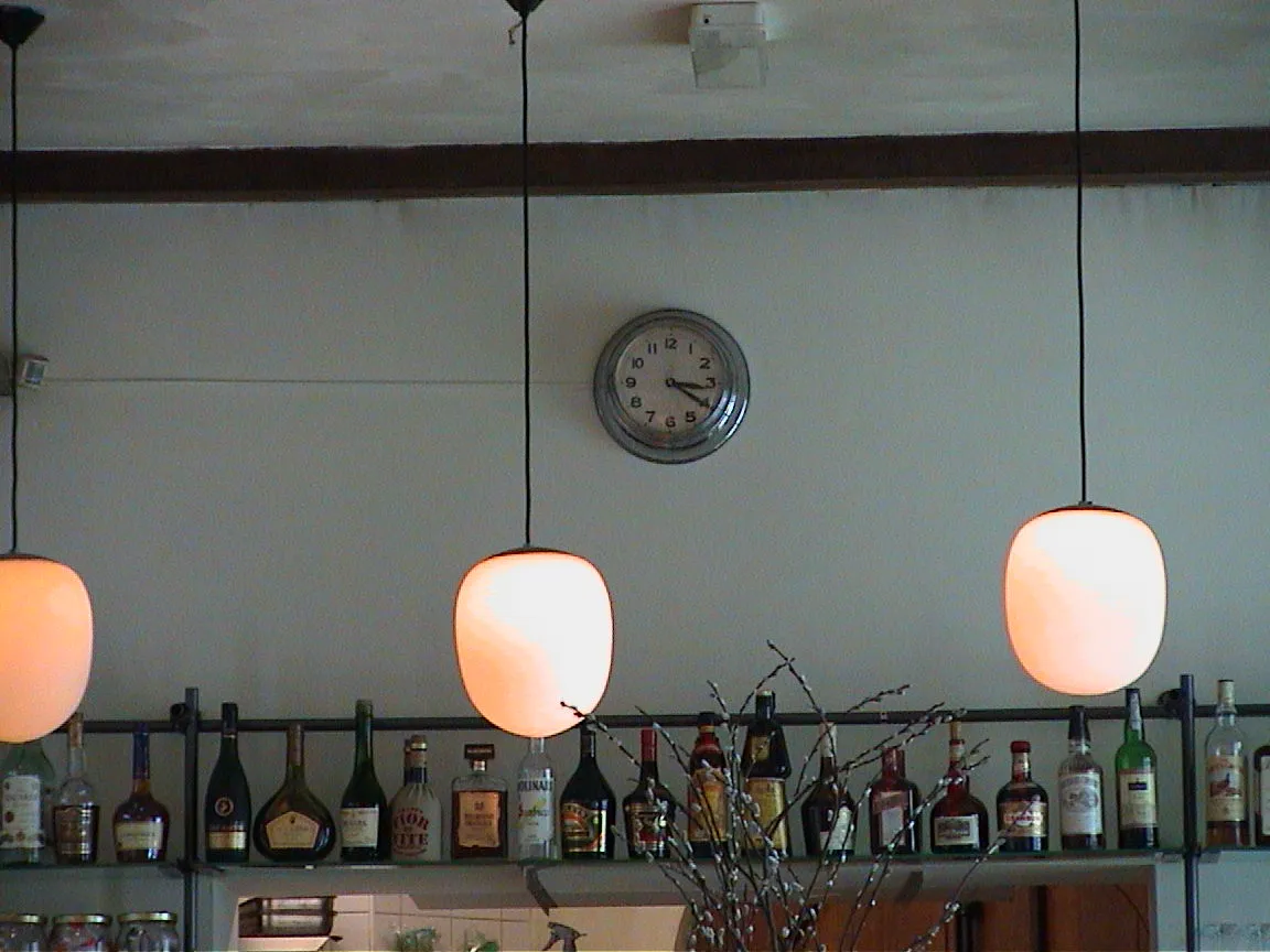A clock in a bar points at 20 past three.