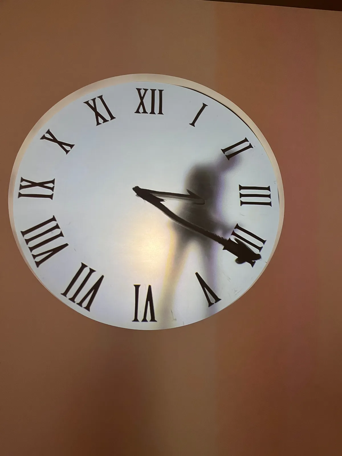 It looks like there’s somebody inside this clock, who is drawing the hands onto the face of the clock. These drawn hands point at 21 minutes past 3. 
