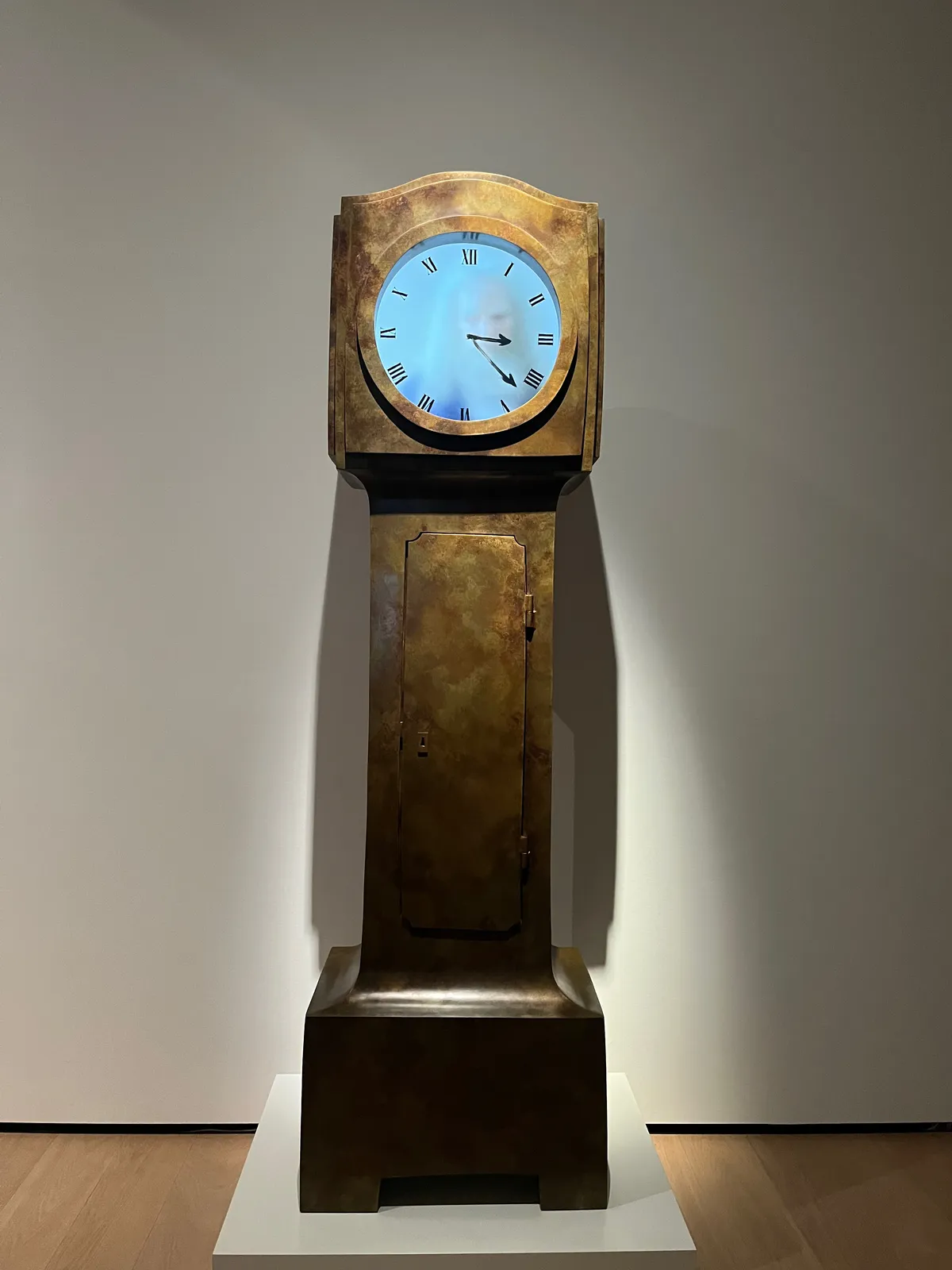 It looks like there’s somebody inside this clock, someone who just fits inside it. This old, bearded man is drawing the hands onto the face of the clock. These drawn hands point at 22 minutes past 3. 