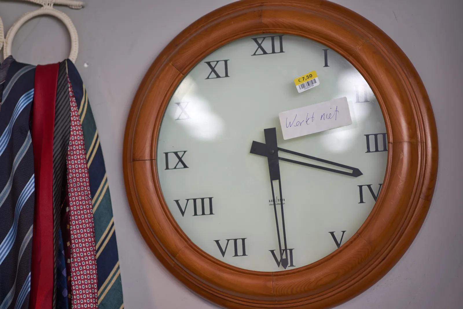Next to a bundle of ties there’s a pretty large clock. On the clock there’s a price sticker (7,50) and a sticker that says that the clock doesn’t work. The clock points at approximately half past three though. So right now it works.