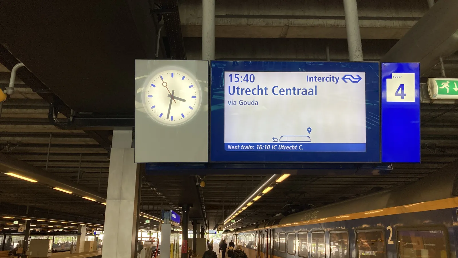 A train on a station. There’s also a clock that points at 32 minutes past 3.