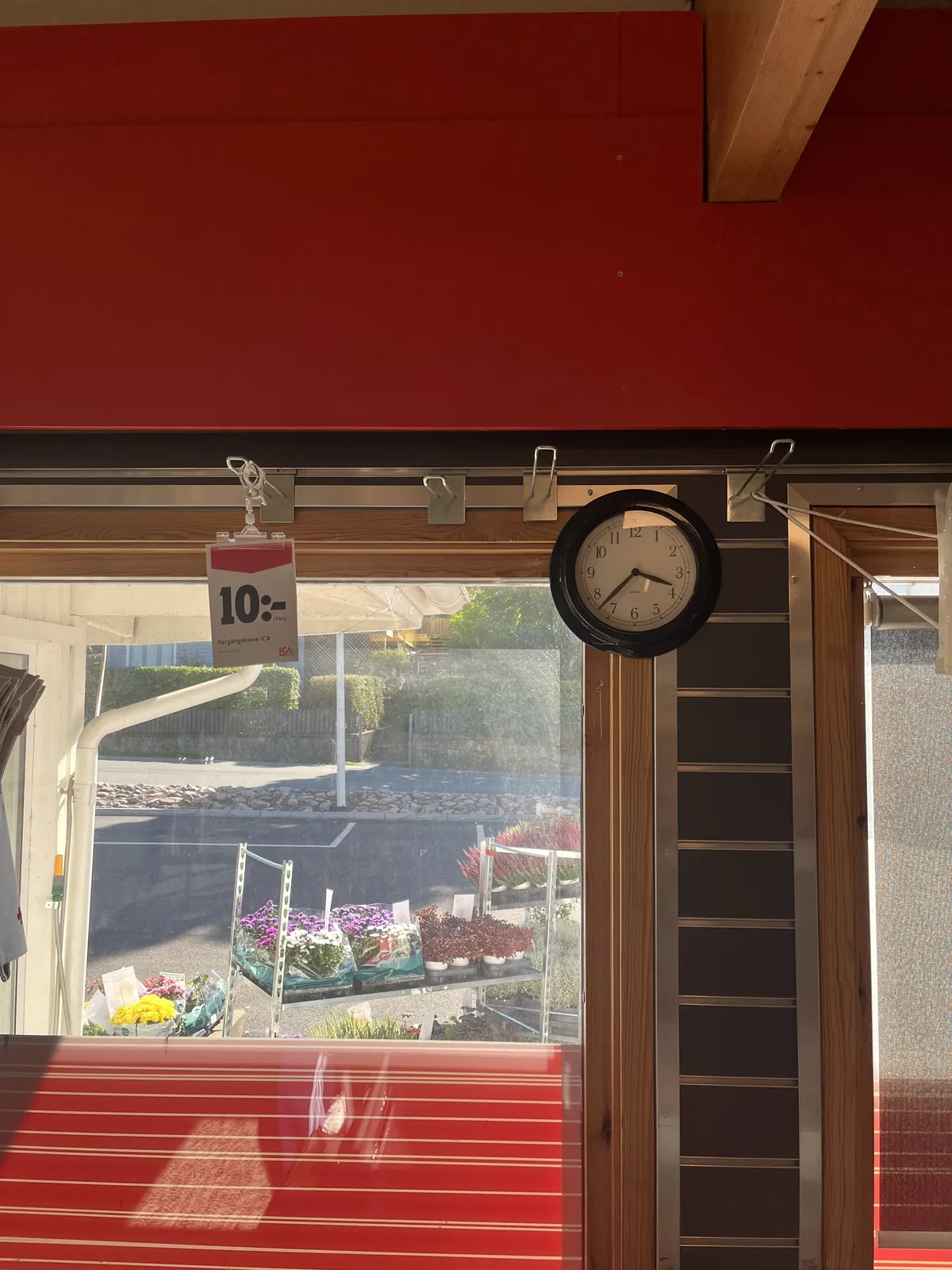 There’s a bright red panel above the window, and the lower side of the window is stickered red as well. A price tag is selling the voind for 10, and a small clock points at 37 minutes past three.
