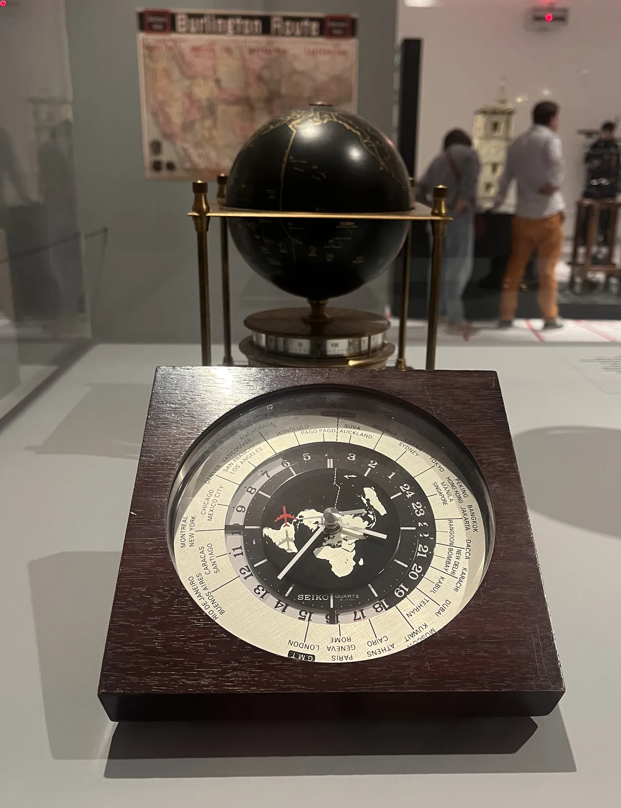 A world clock that somehow shows the timezones. Its second hand has a little aeroplane on its tip, which seems to fly around the world. The clock shows that is it 37 minutes past 3 in Pago Pago.