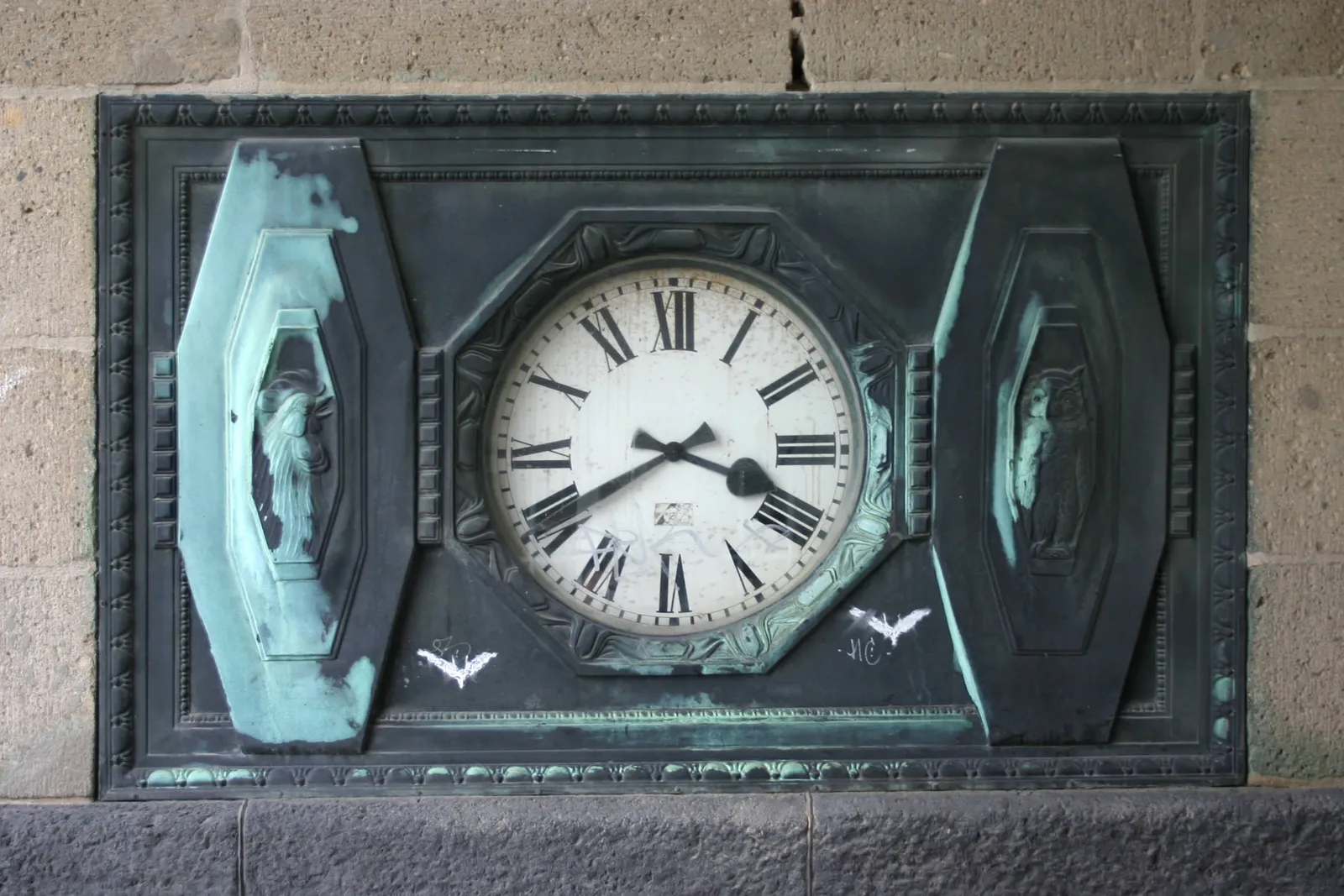 A clock in a cast iron frame. It says it is 40 minutes past 3.