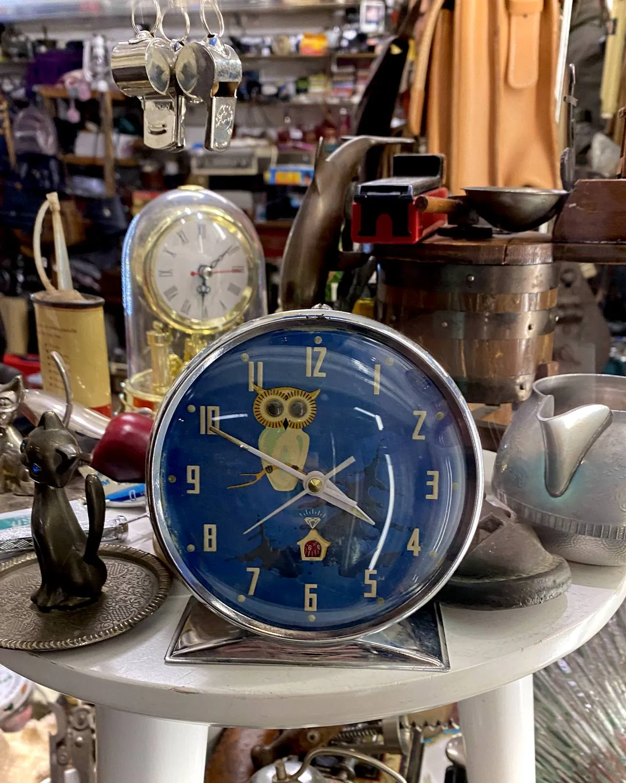 This clock with an owl printed on its face points at 11 minutes to four.