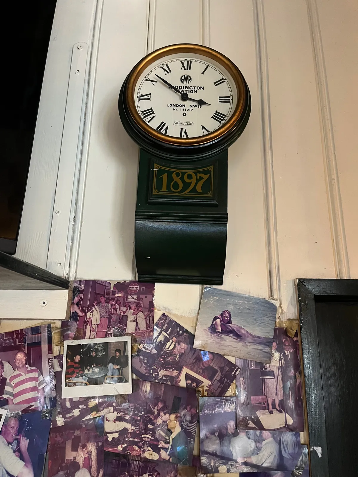 Lots of pictures of people in a bar. Above the collage there’s a clock which points at 8 minutes to 4.