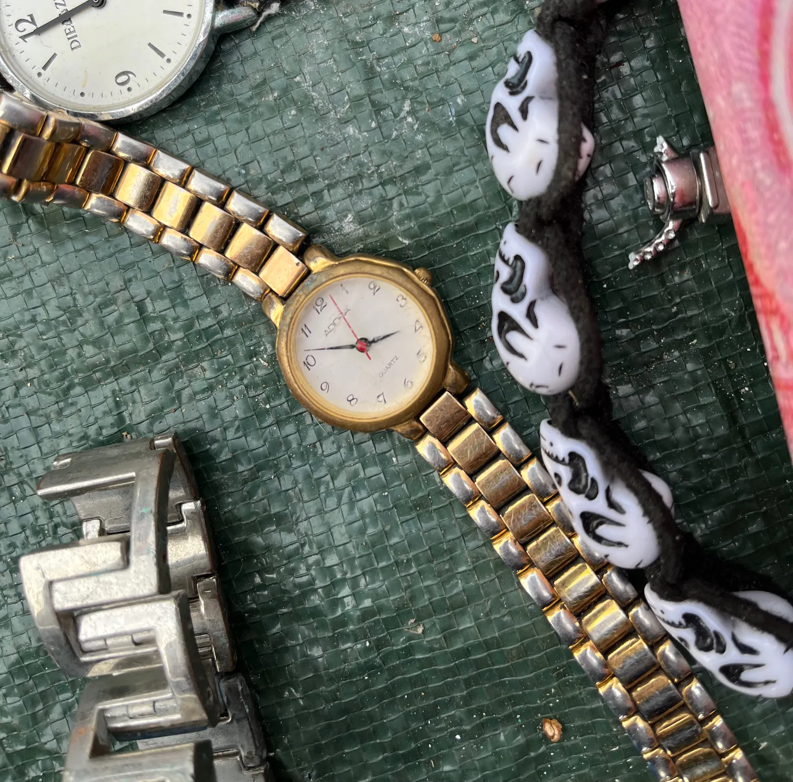 A watch, surrounded by other watches and all kinds of stuff, points at 8 minutes to four.