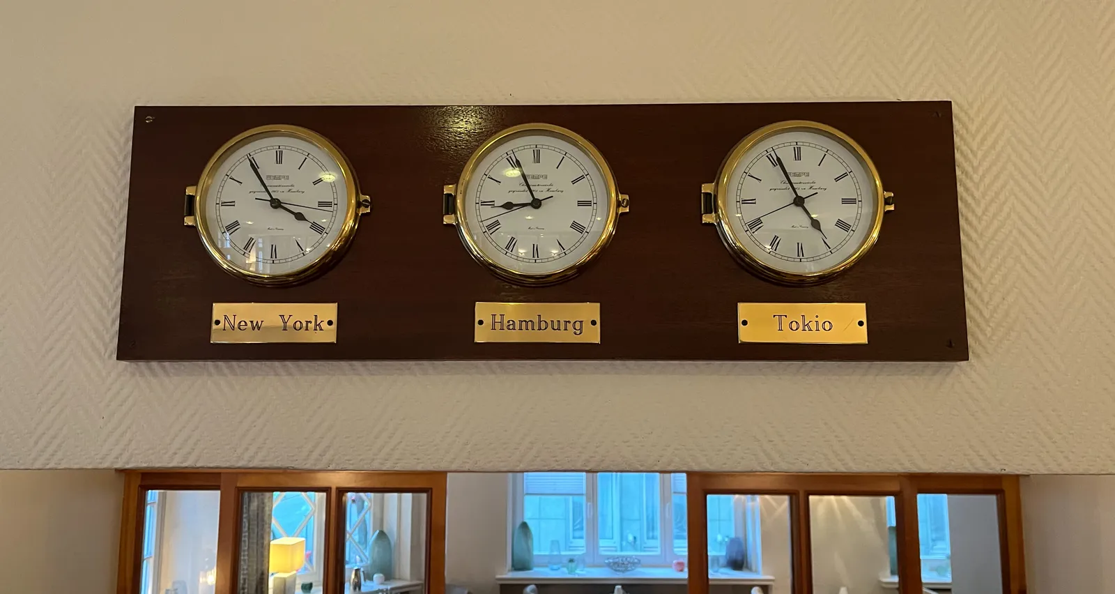 Three clocks that show the time in New York, Hamburg and Tokyo. The one that shows the time in New York points at 6 minutes to 4, which is correct.