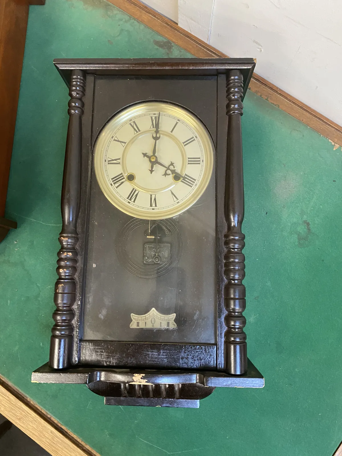 An old wooden clock points at one minute past 4.