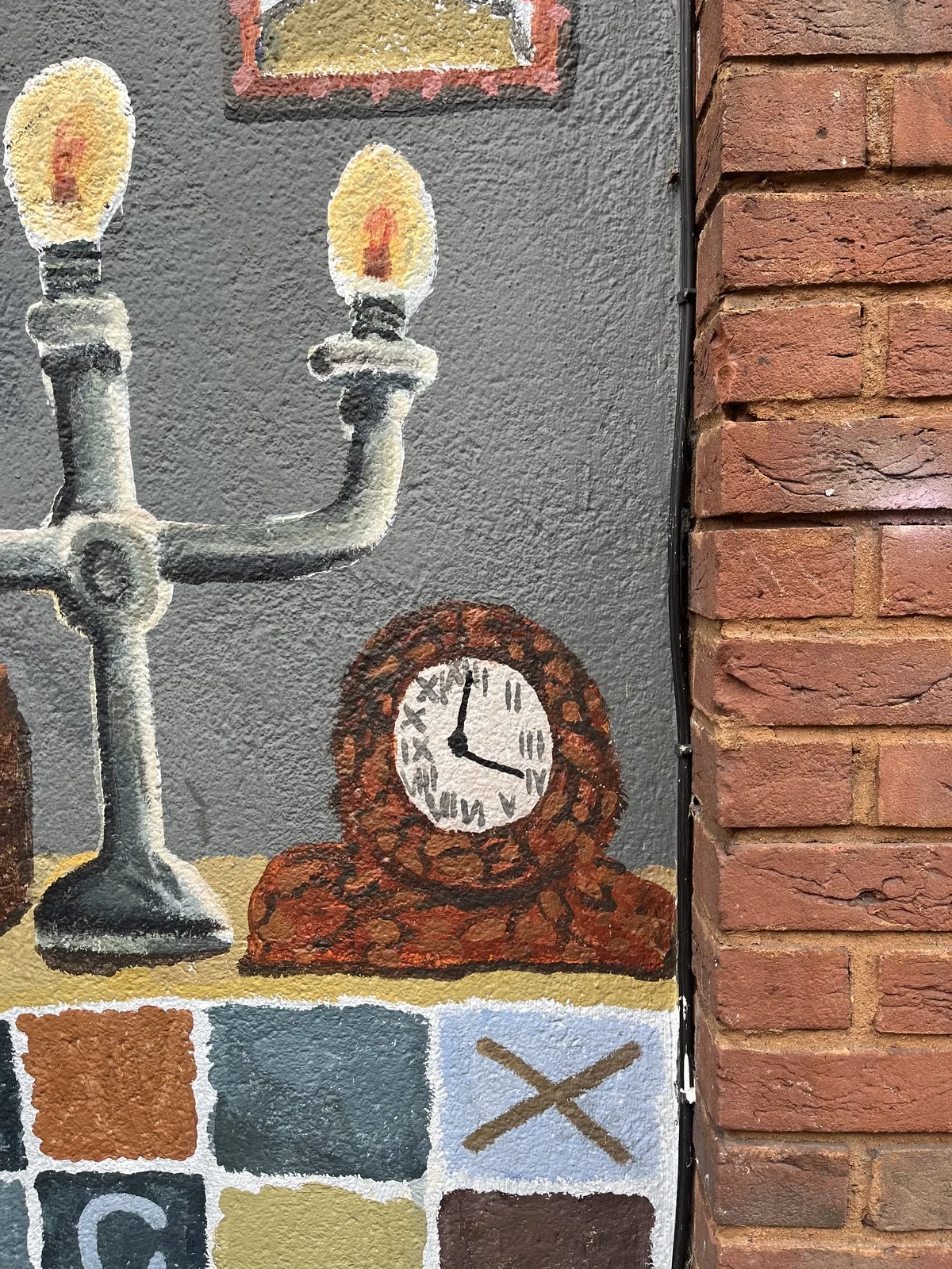 A wall painting, with a chandelier and a mantel clock. The clock points at one minute past four.