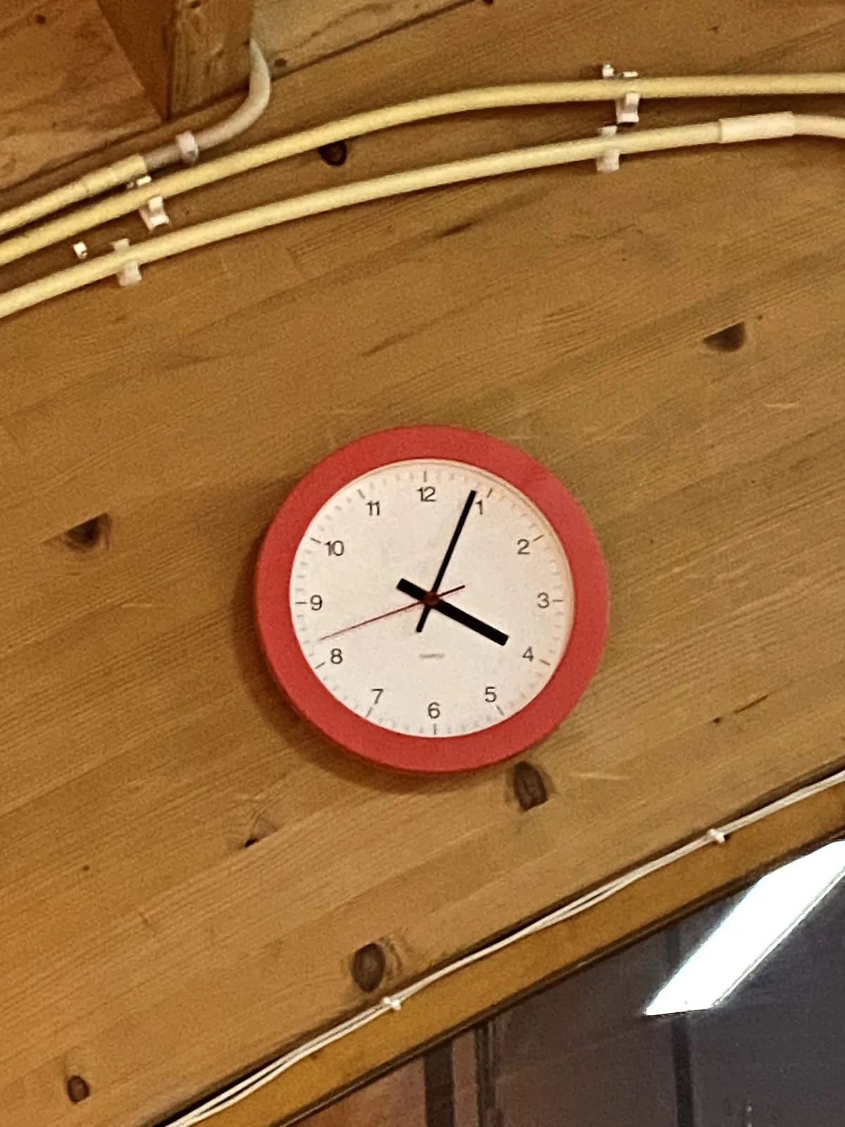 There are some wires on a wooden panel. Or is it a staircase? It seems like it, given the angle of the wood. There’s also a clock, which points at 4 minutes past 4.