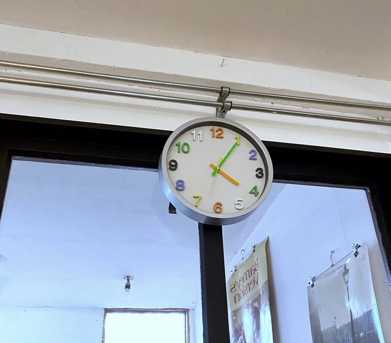 A rather common clock, except for the colourful numbers, which is rather uncommon. The clock points at 5 past 4.
