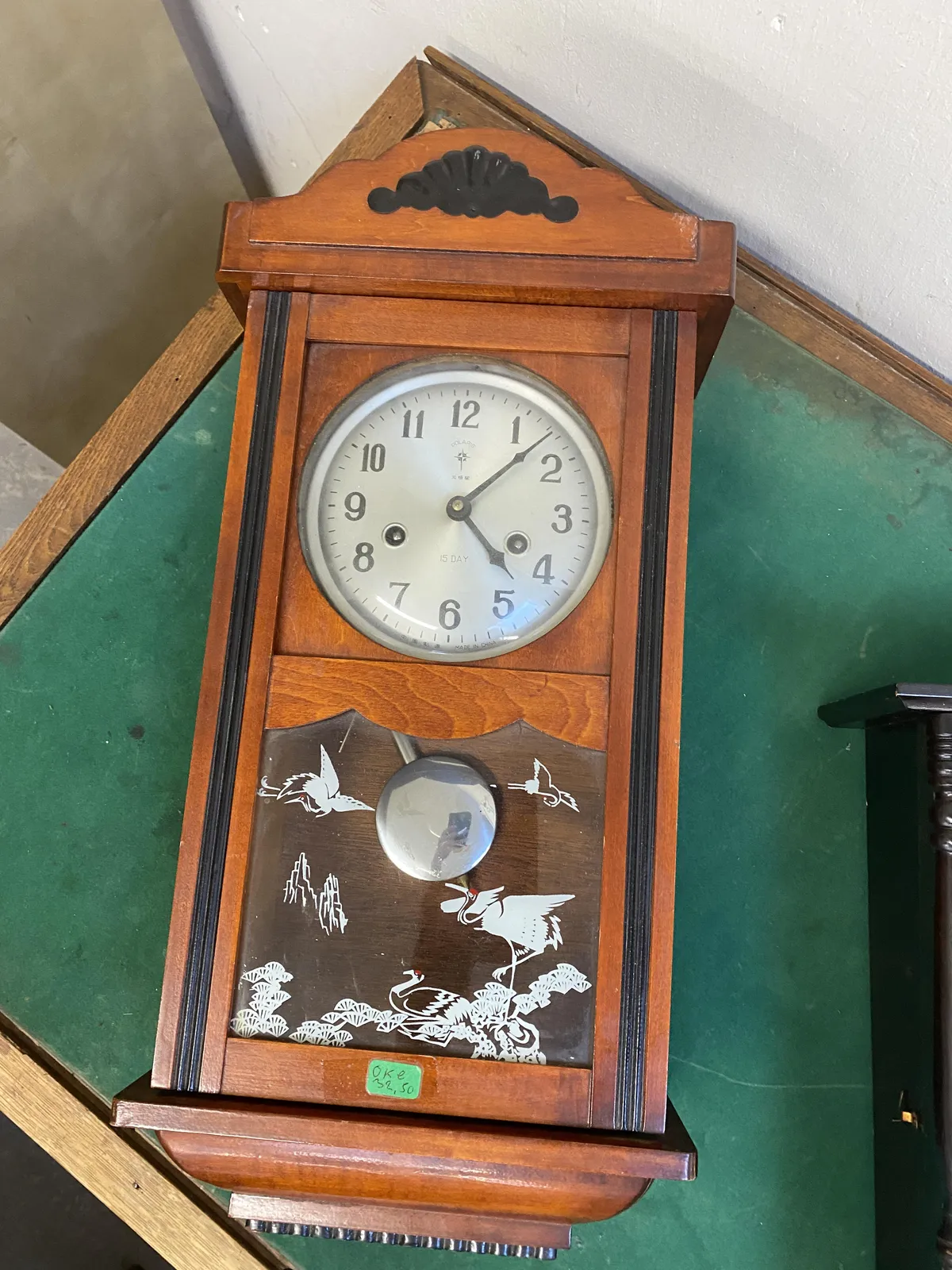 A wooden clock with some ornamental white birds on the glass pane. It points at 7 past 4.