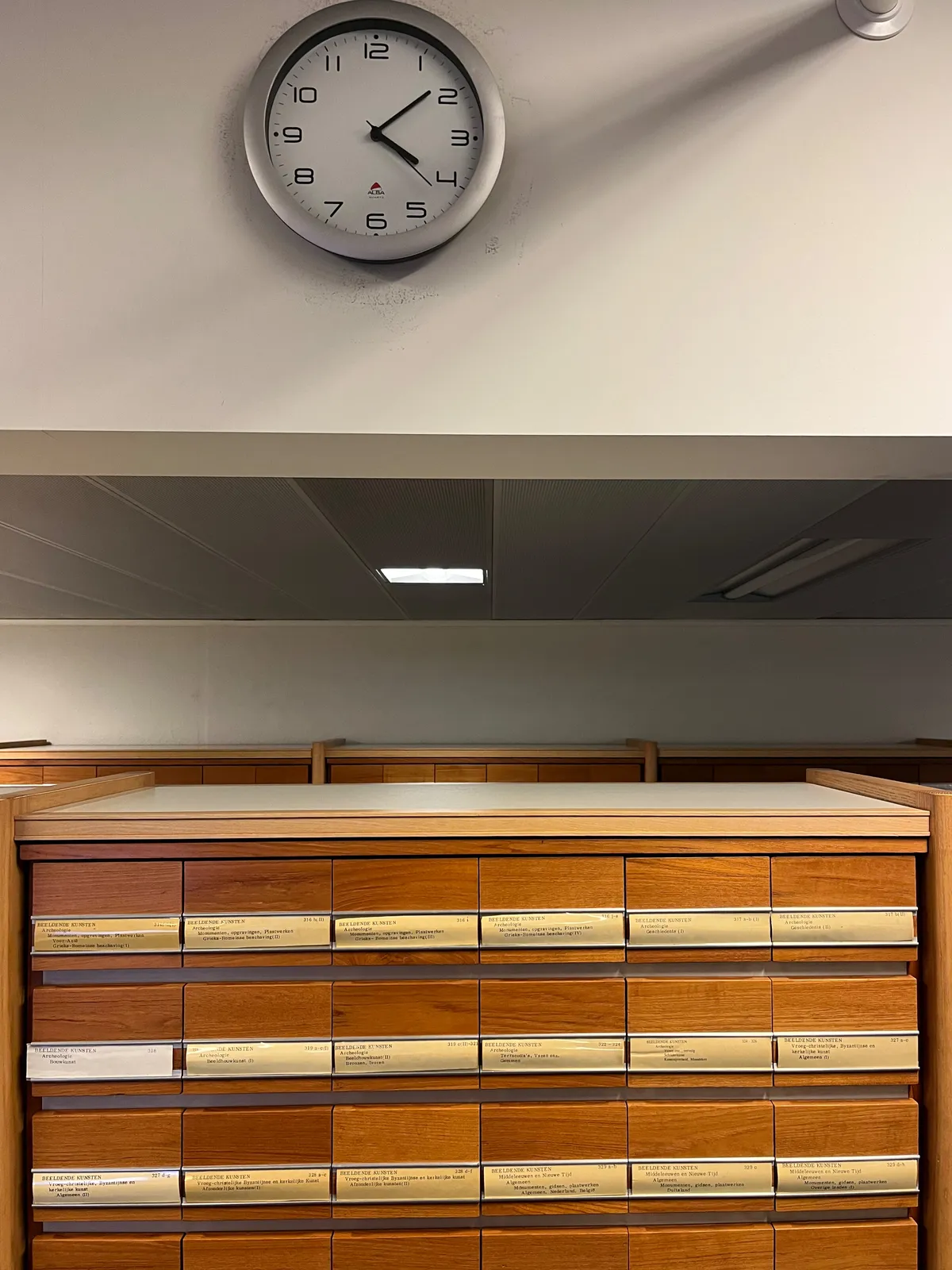 There are filing cabinets. There’s also a clock which points at 8 minutes past 4.