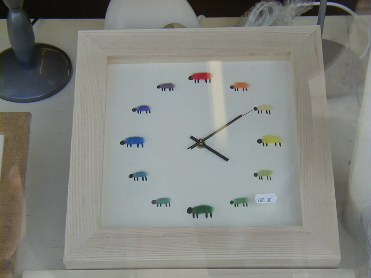 A clock with coloured sheep instead of numbers points at ten minutes past four.