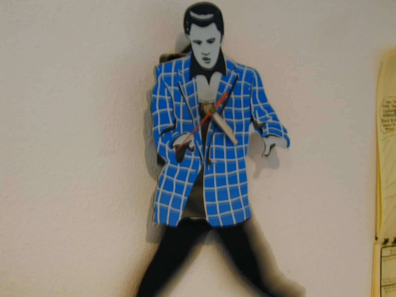 An Elvis Presley shaped clock says it is twenty past four.