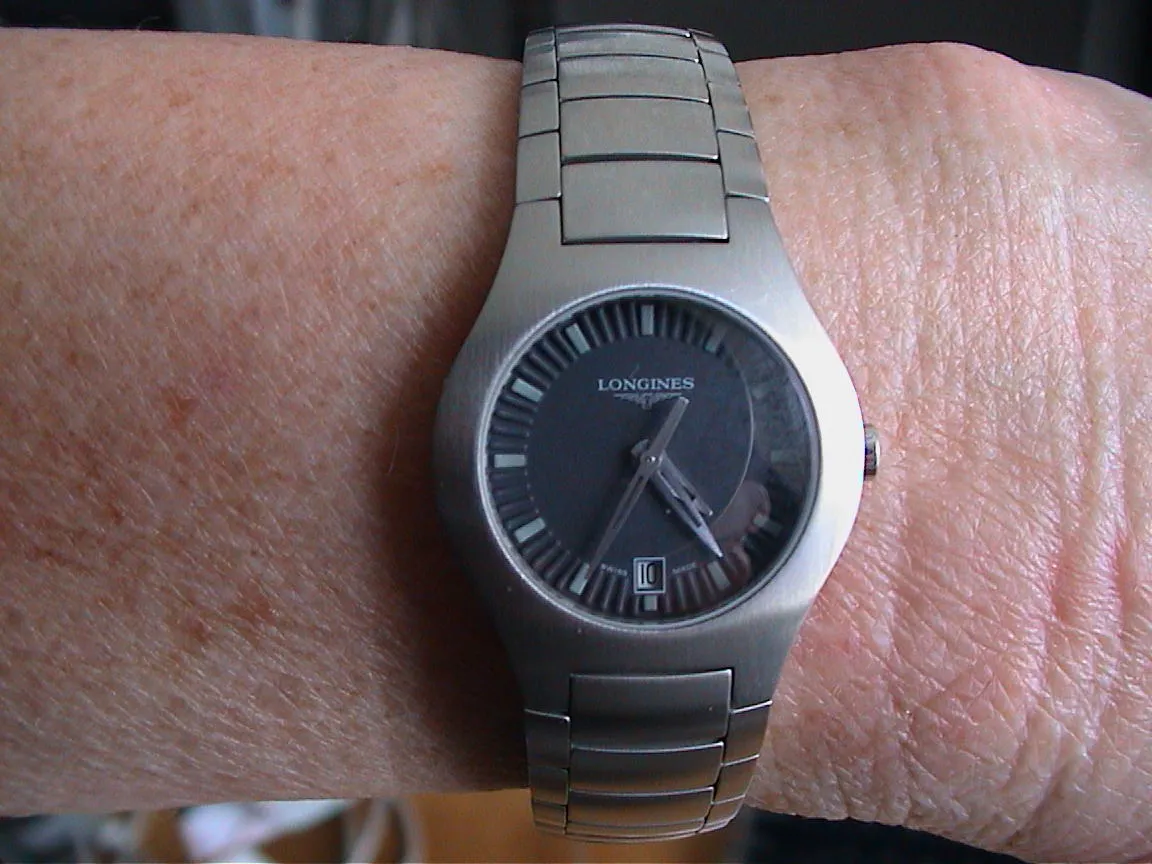 A wrist watch points at 24 minutes past four.