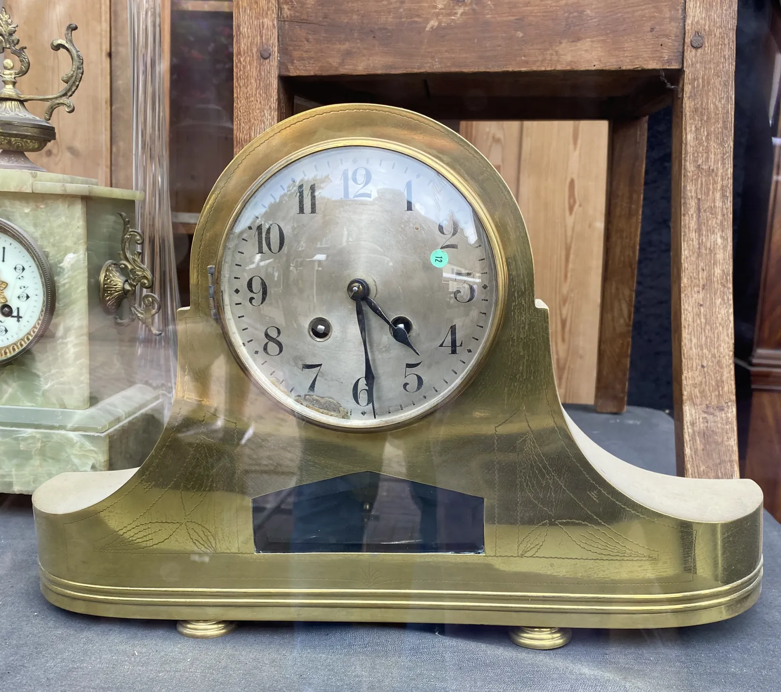 An elegant, metal mantel clock. It points at 29 minutes past 4.
