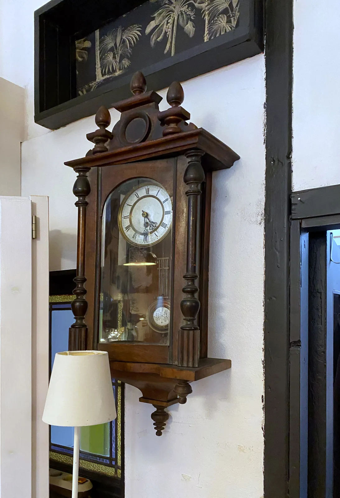 An old wooden clock. It points at 29 minutes past 4.