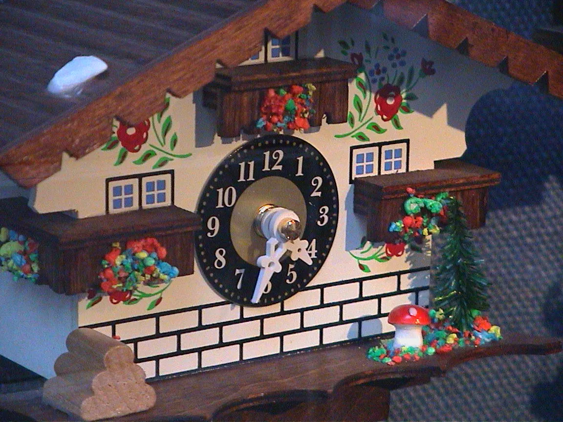 A clock in the shape of a Swiss chalet points at 32 past four.