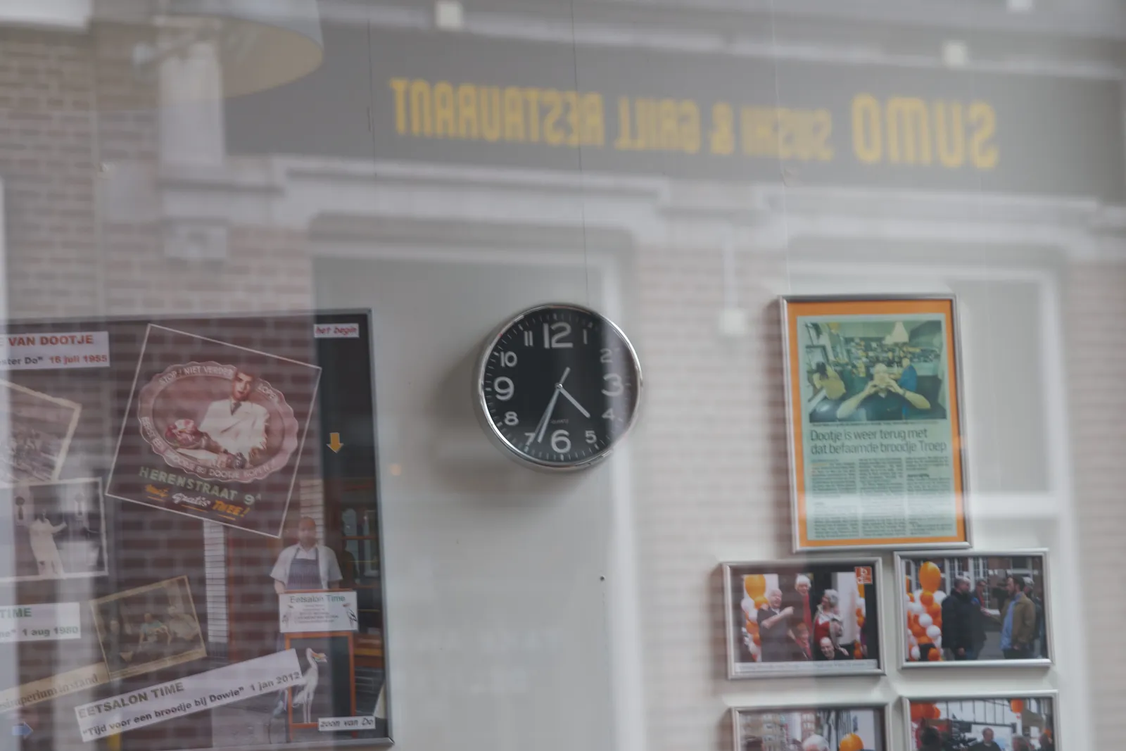In the reflection you can see a restaurant on the opposite side of the street. Through the shopping window there’s, among others, a clock. According to this clock it is 33 past 4.