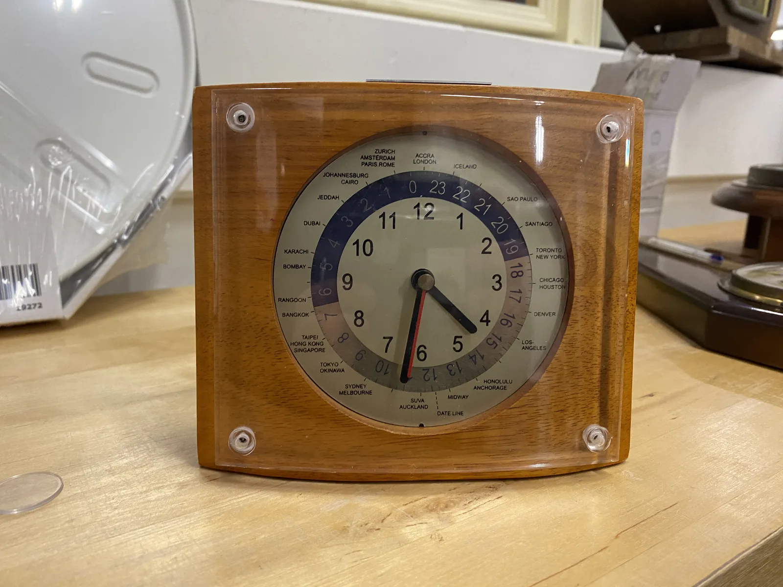 A wooden world clock, with all kinds of indicators that somehow show what time it is in different cities in the world. It points at 34 past 4, but it is not clearly aligned with any city, so it’s not clear if it actually is 34 past 4.