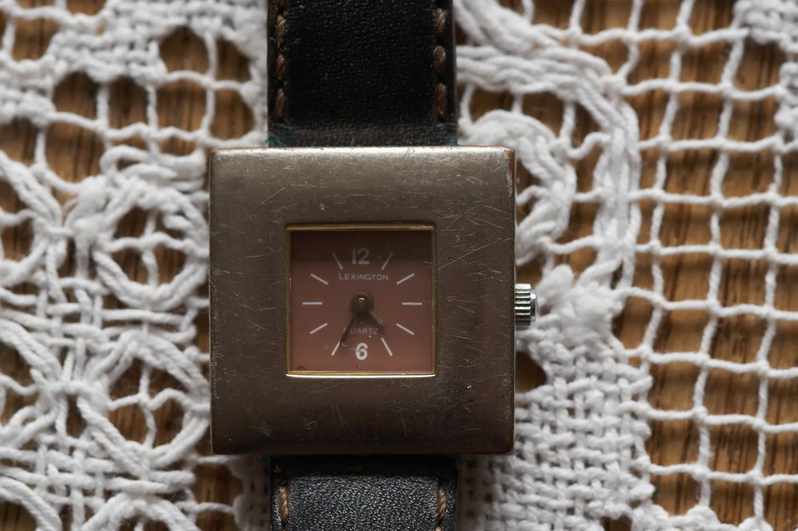 This small watch with a large silver frame, points at 35 past 4. 