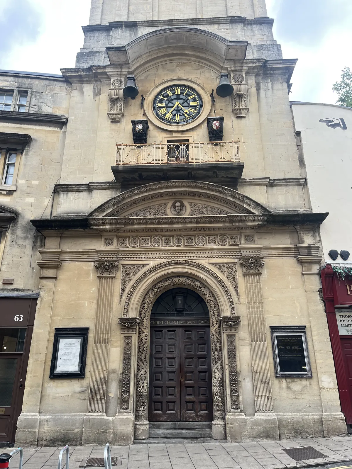 An old, church like building with quite some decorations. There’s a clock built into the facade, which points at 36 minutes past four.