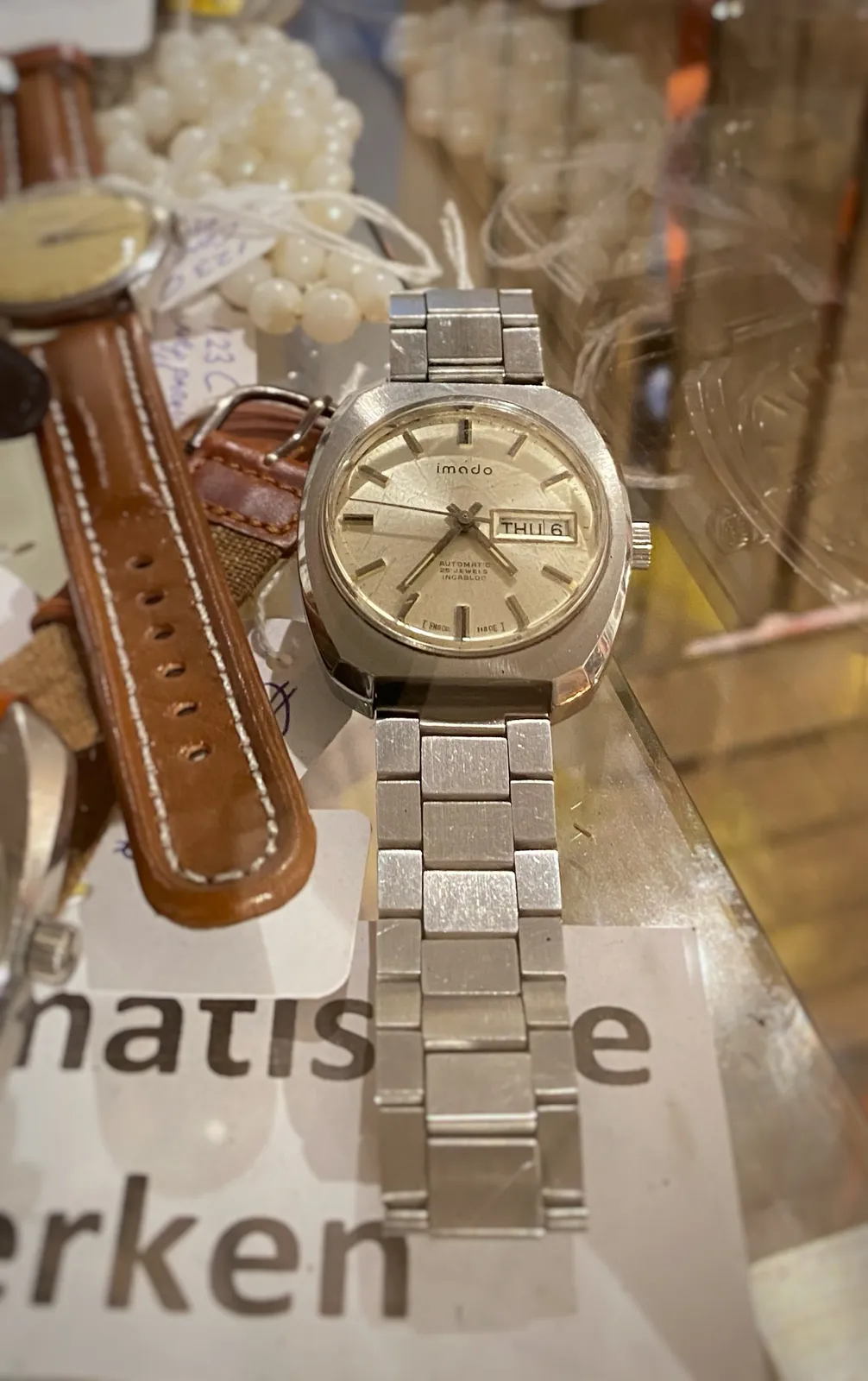 A few wrist watches on display. Just one of them is clearly in focus. It points at 24 minutes to 5.