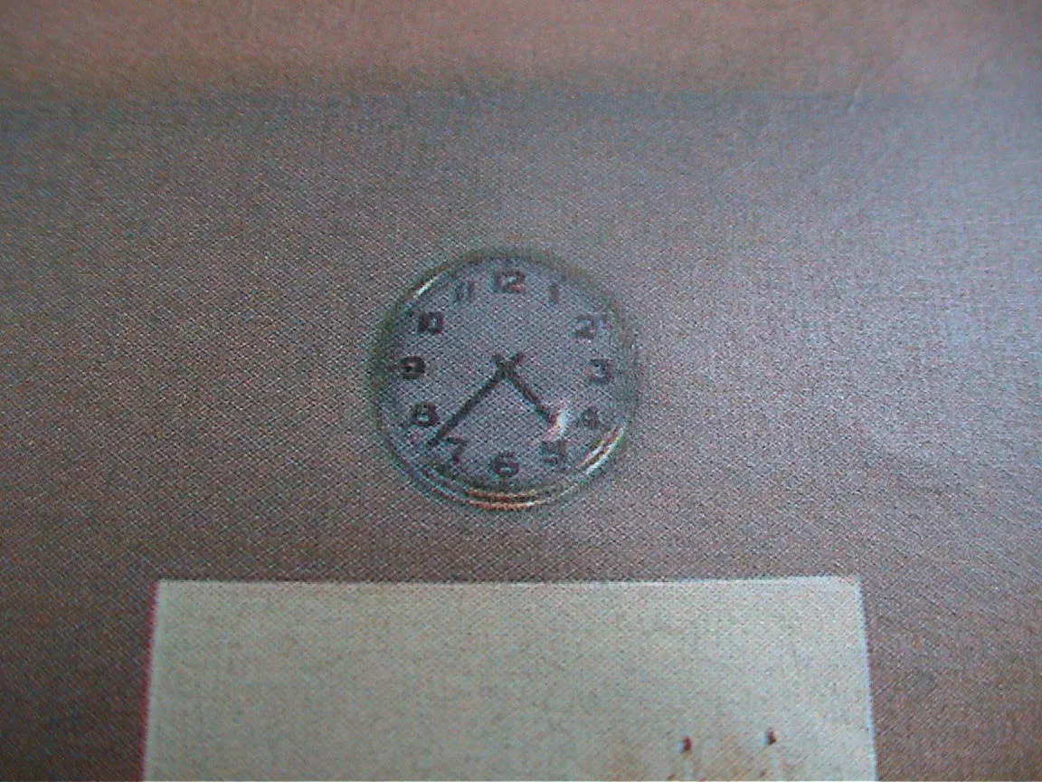 The clock on this unsharp image points at 37 past four.