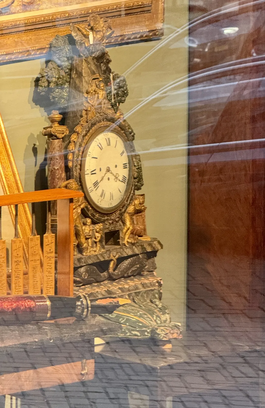 An antique, richly ornamented clock. It points at 20 minutes to five.