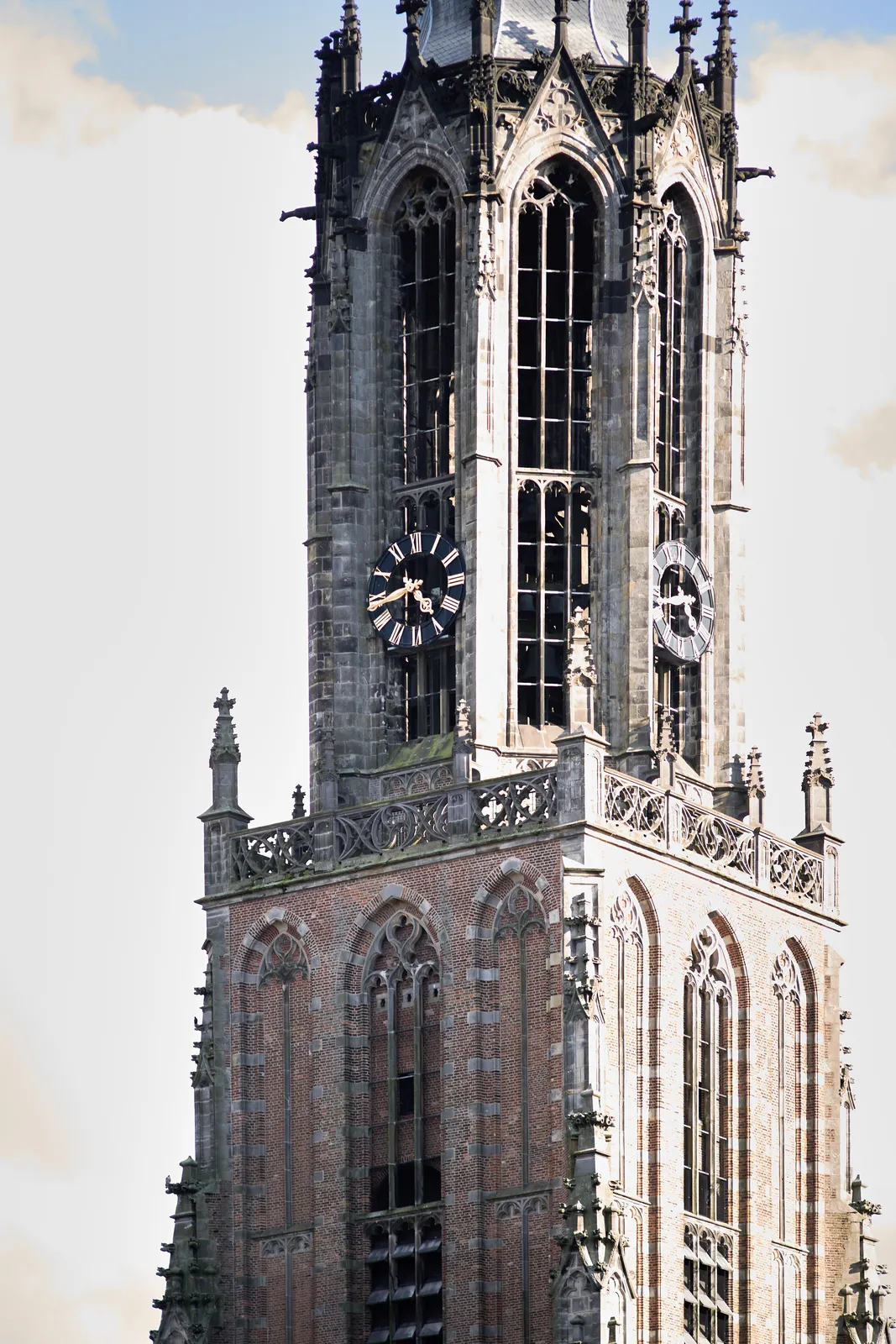 A gothic church tower with a clock on it that points at 17 minutes to 5.