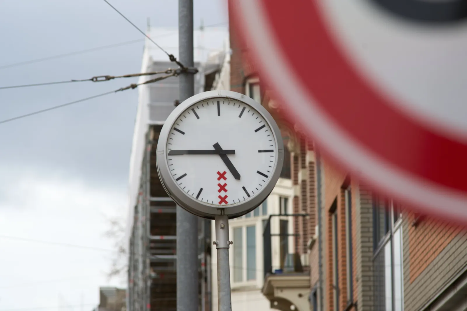 A clock in an Amsterdam street. It points at a quarter to five.