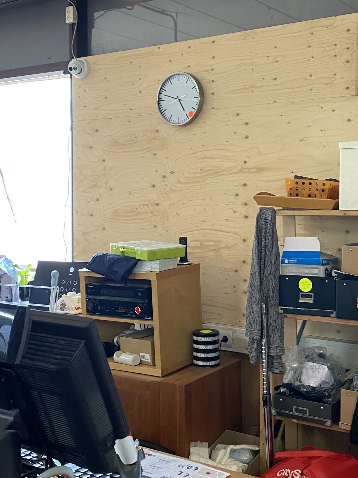 This is either a messy shed, or a messy thrift shop. There’s a clock on the wall that points at 13 minutes to 5.