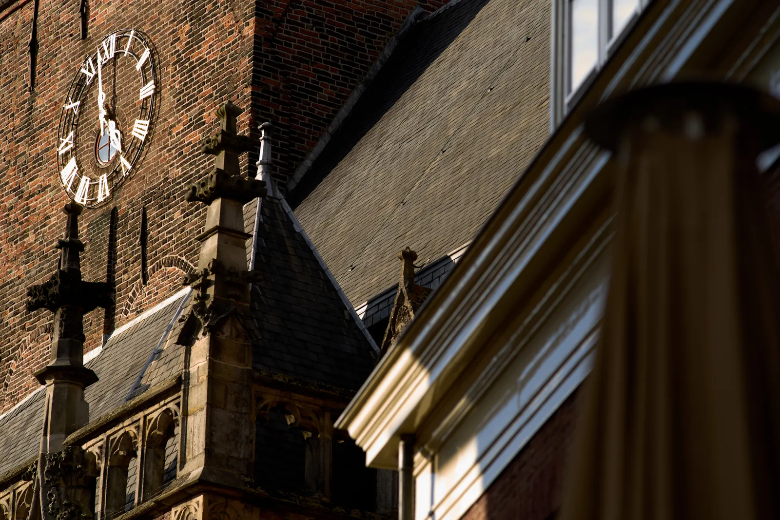An old brick building, slate-roofed. There’s a clock on it that points at 2 minutes to 5.