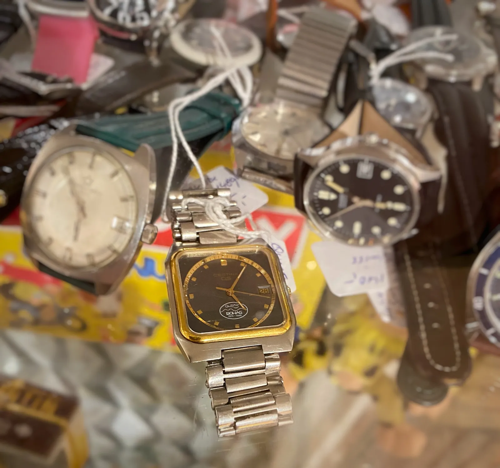 Quite a few wrist watches on display here. Just one of them is clearly in focus. It points at six minutes past five.
