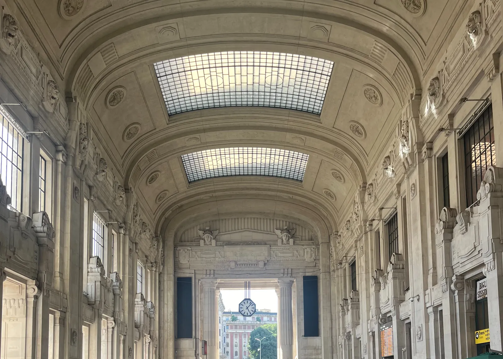 One of the ridiculously large halls in Milano central station. In the back there’s a clock that points at 7 minutes past 5.