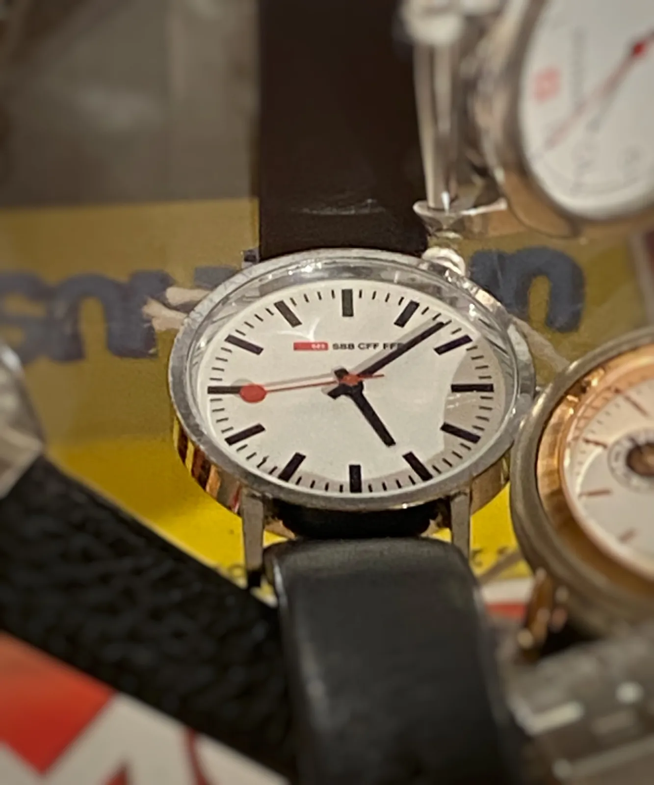 A few wrist watches, most are cut off by the frame of the picture. Only one is clearly visible and in focus. It points at 7 minutes past 7.