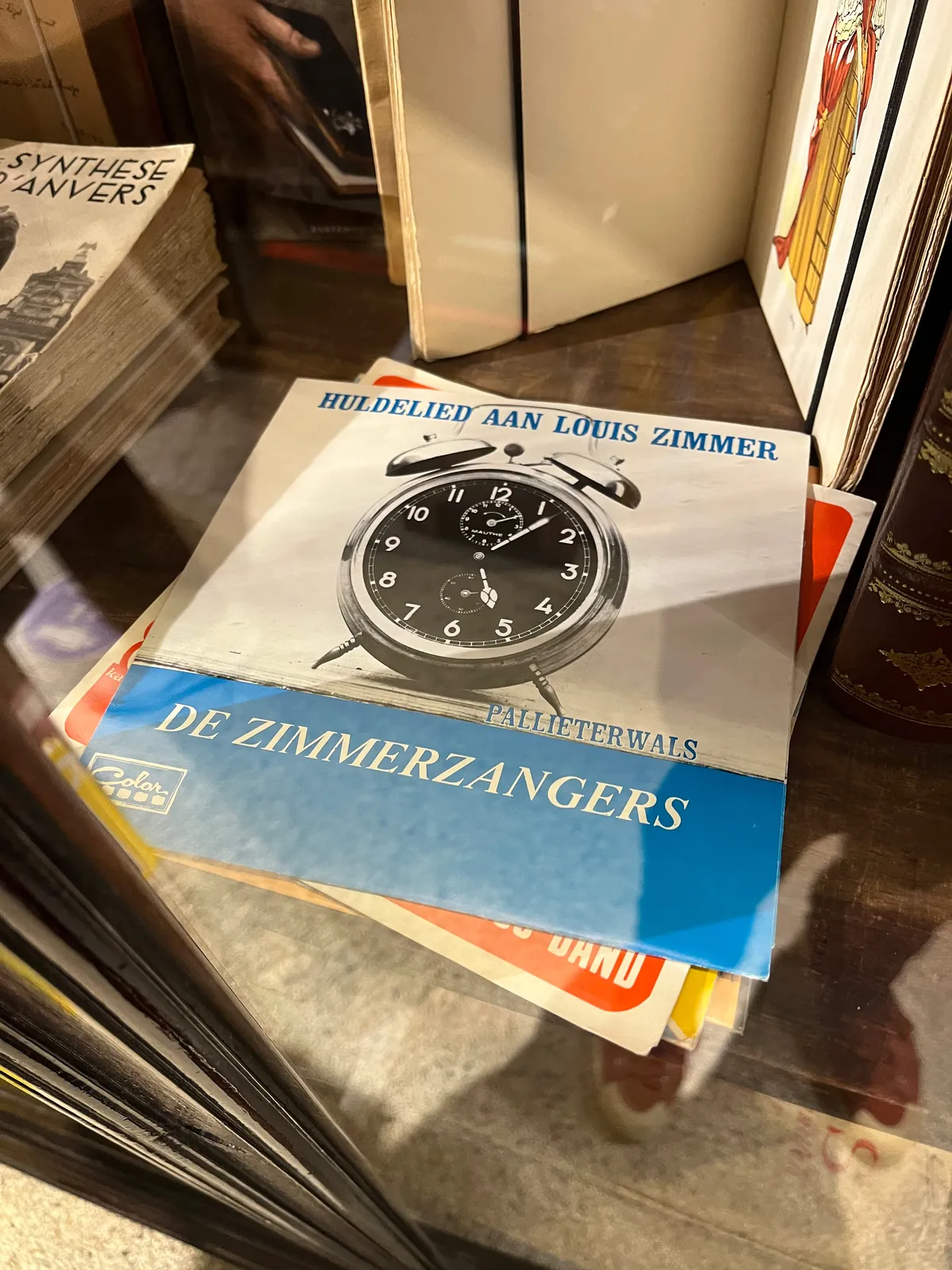 An old vinyl record sleeve from De Zimmergangers. In it is an image of an old alarm clock. It points at 7 past 5.