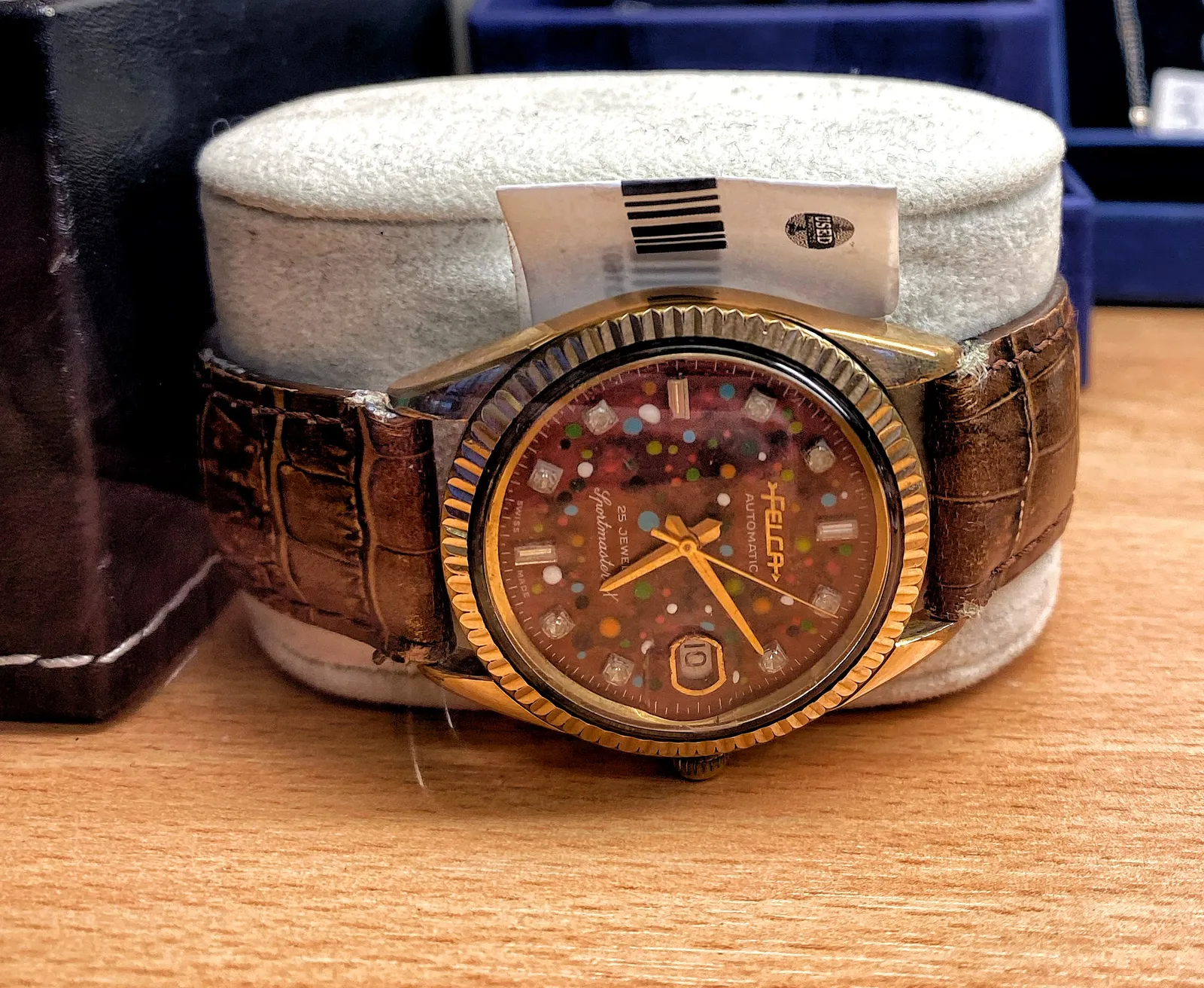 A somewhat expressive wrist watch. It says it is a Felca (of a Feica) Automatic, 25 jewels sportsmaster. It points at 10 past 5.