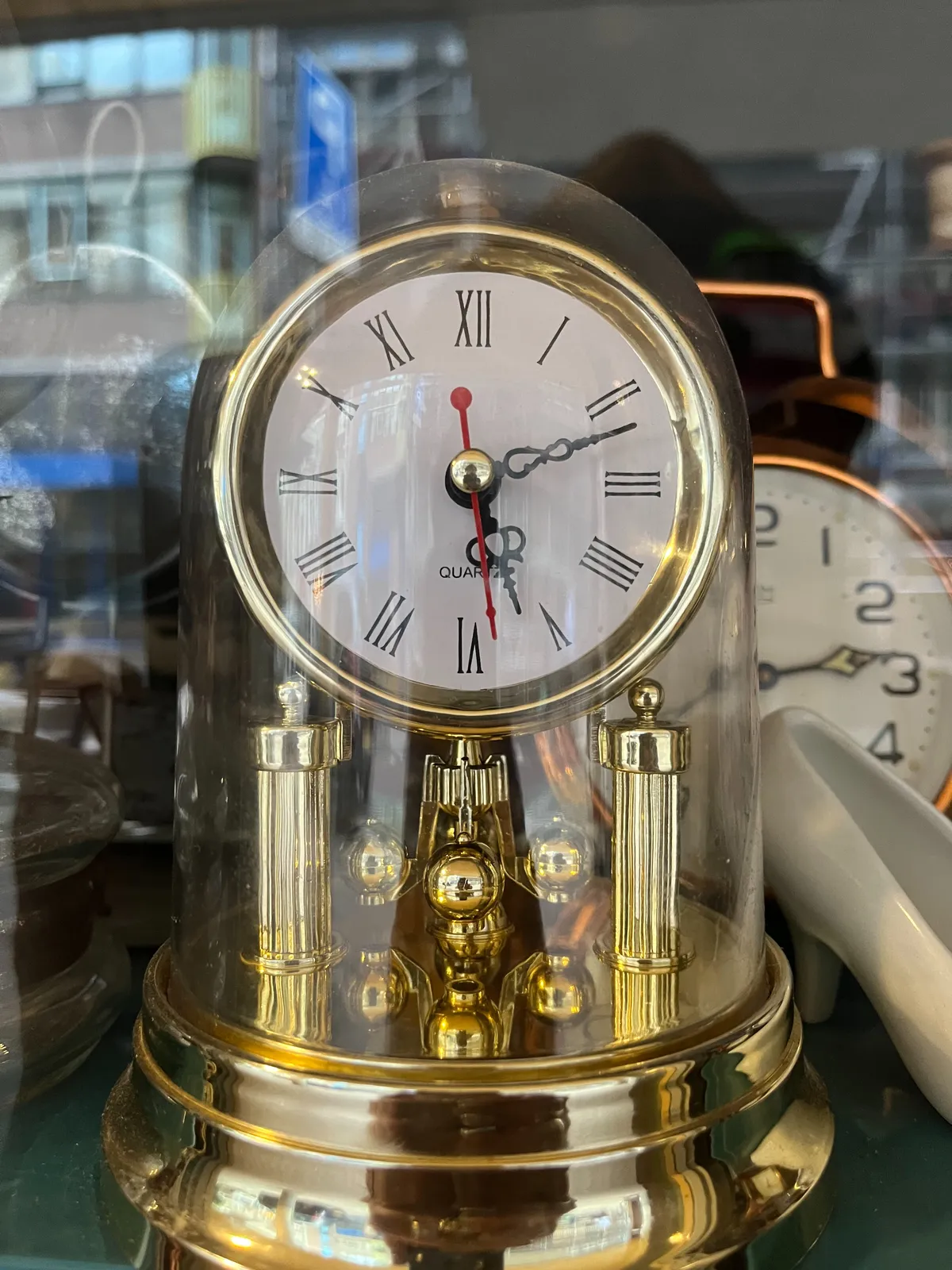 A very shiny clock, with something that looks like a golden mechanism, but probably isn’t. On the face it says Quartz, and quartz clocks don’t need mechanisms. It points at 12 minutes past 5.