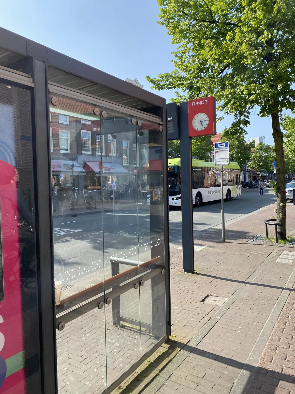At a bus stop the clock points at 14 minutes past 5.