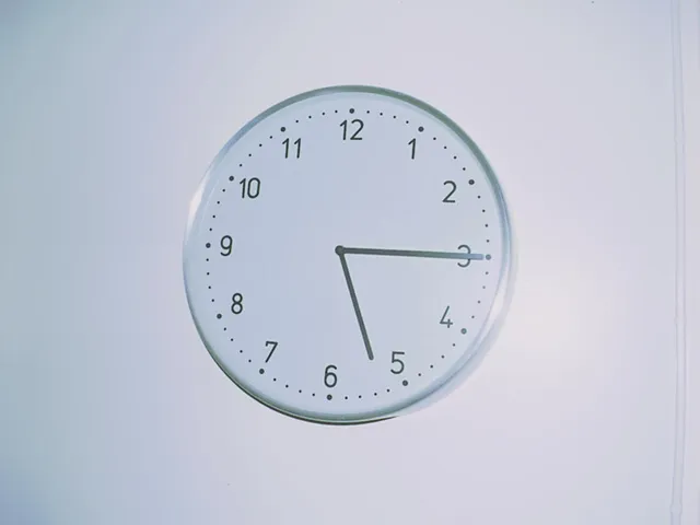 A clock on a wall points at a quarter past five.